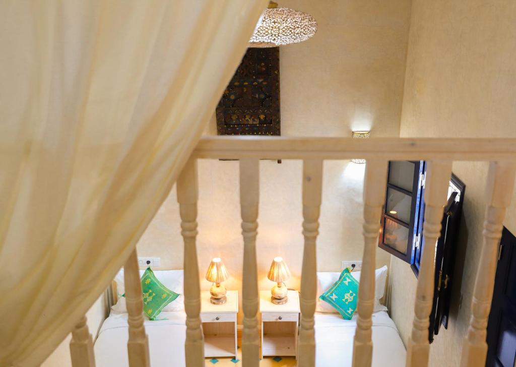 un escalier avec deux tables avec des lampes dessus dans l'établissement Riad YAHIA ZAMANE, à Essaouira