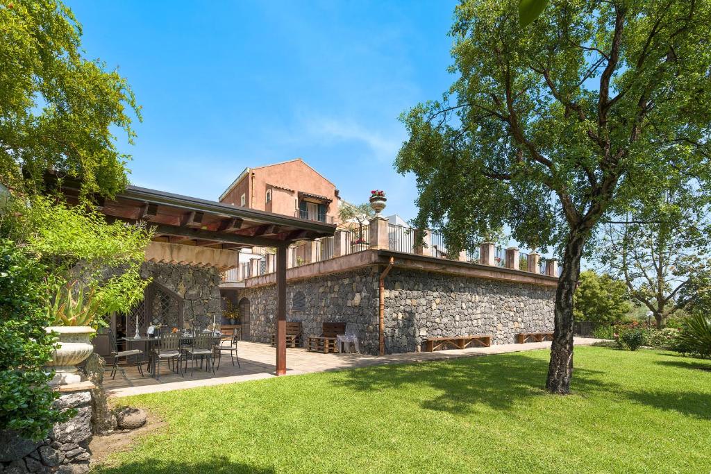 Elle offre une vue sur l'extérieur d'une maison en pierre dotée d'une terrasse. dans l'établissement Saracina, à Aci Catena