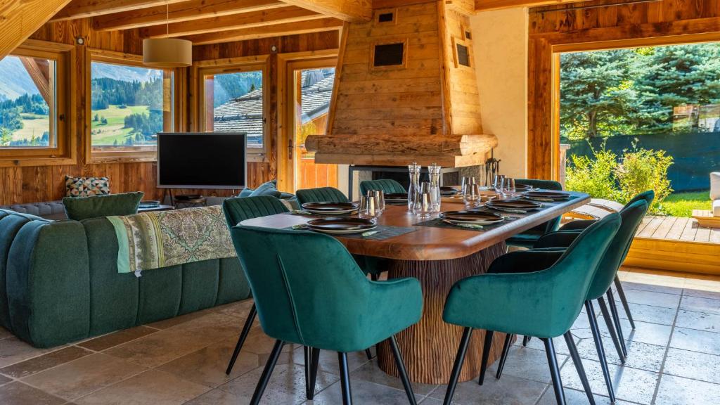 une salle à manger avec une table et des chaises vertes dans l'établissement Chalet Vallée de Chamonix Randonnées, Rafting et Spa, à Saint-Gervais-les-Bains