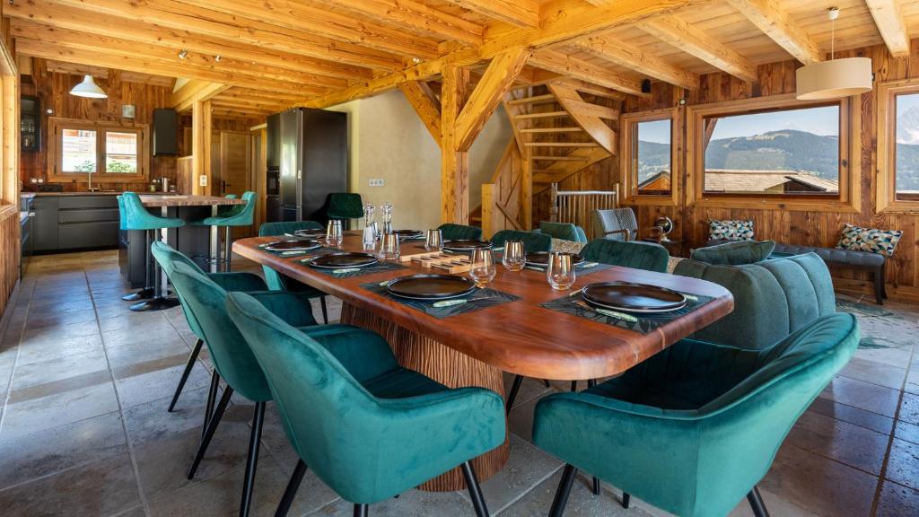 une salle à manger avec une grande table et des chaises vertes dans l'établissement Chalet Vallée de Chamonix Randonnées, Rafting et Spa, à Saint-Gervais-les-Bains