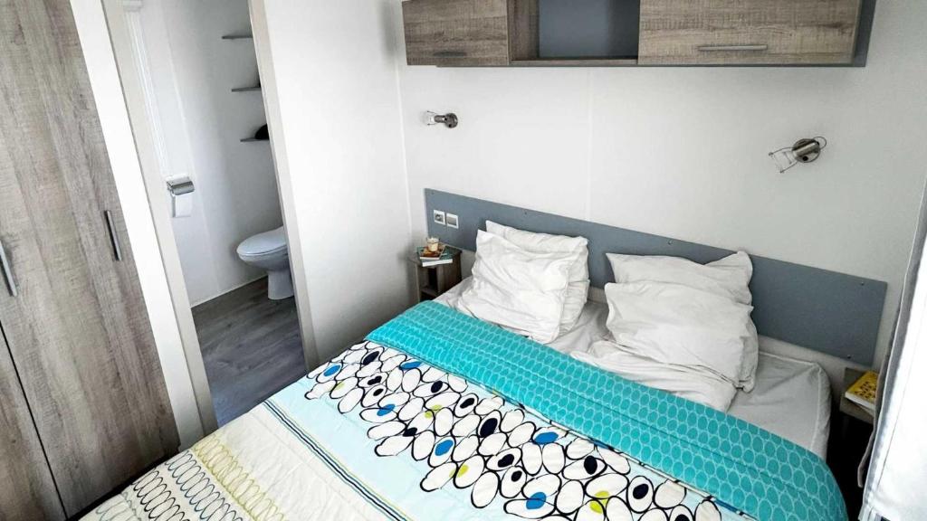 - une petite chambre avec un lit à tête bleue dans l'établissement Camping 5 étoiles - Parc aquatique - eebaff, au Muy