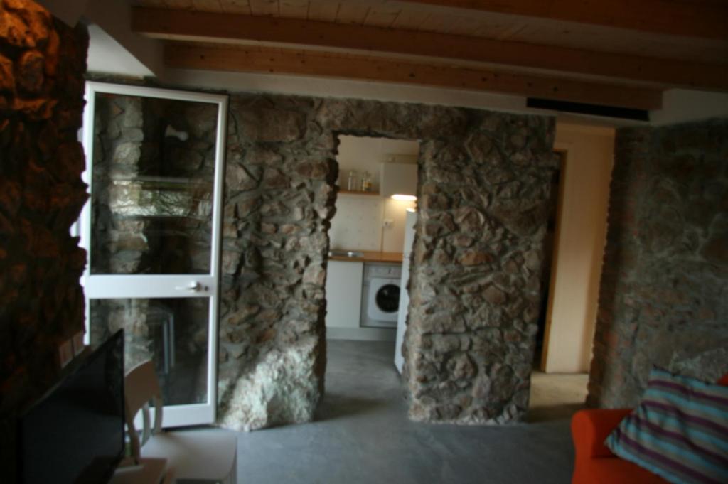 - un salon avec un mur en pierre et un miroir dans l'établissement Andrea's Home, à Cefalù