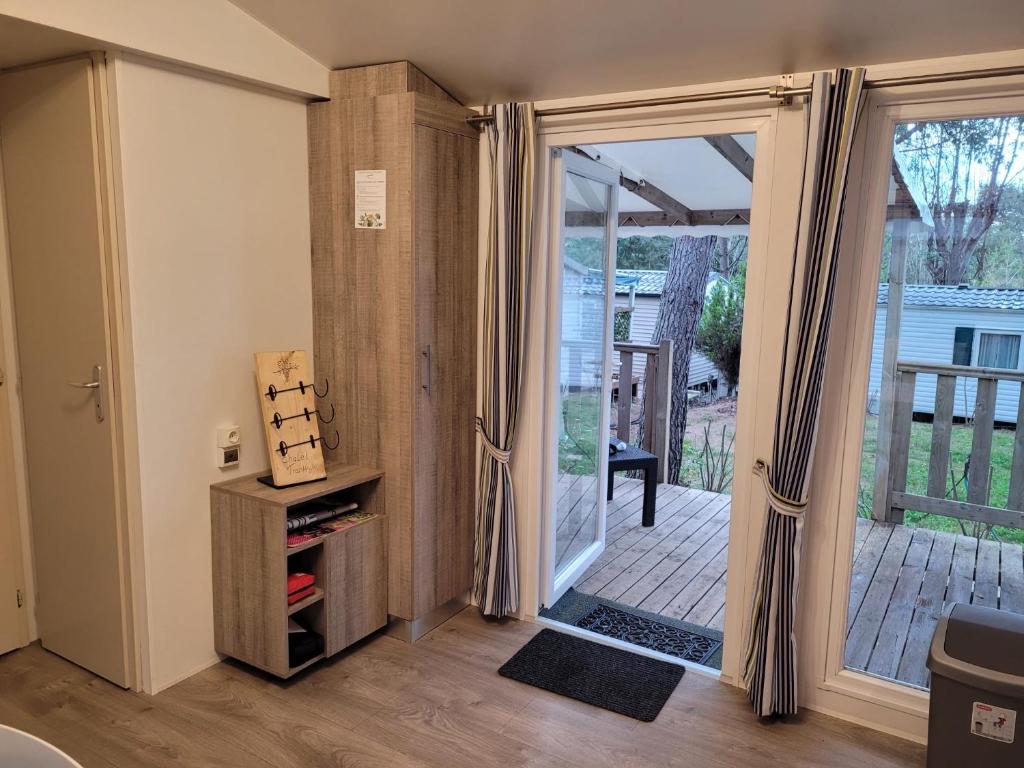 une chambre avec une porte coulissante en verre menant à une terrasse. dans l'établissement Chalet Coco, à Roquebrune-sur Argens