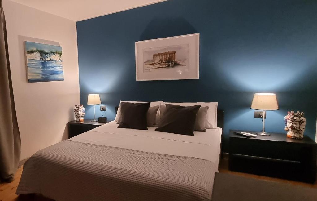 une chambre avec un lit avec un mur bleu dans l'établissement La Maison della Valle, à Agrigente