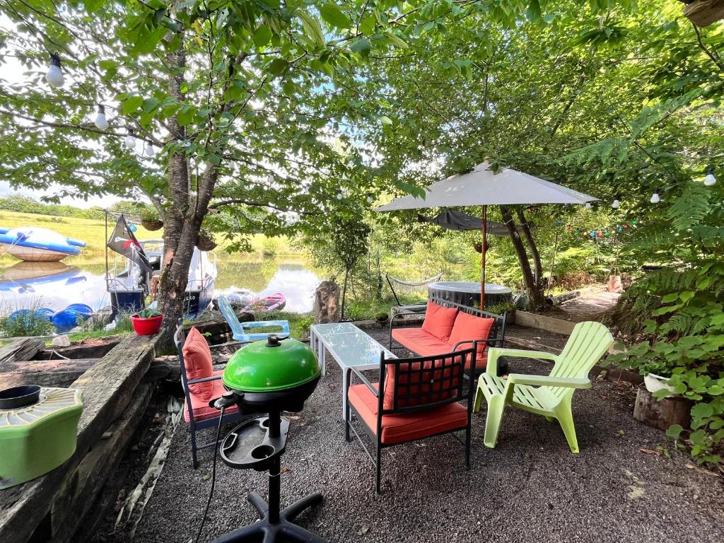 un patio avec une table, des chaises et un barbecue dans l'établissement Bateaupirate19, à Cornil