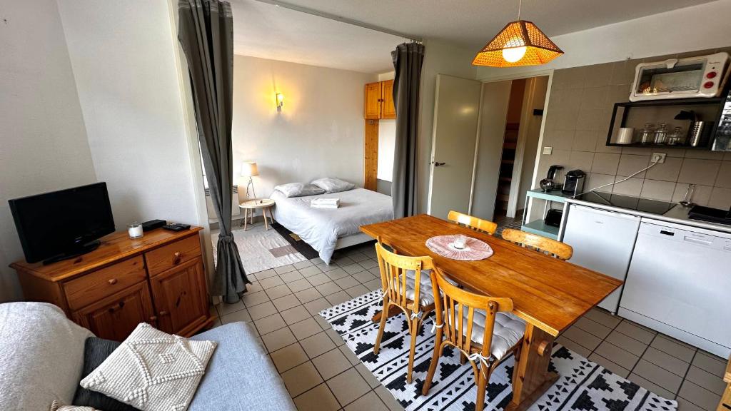 - une cuisine et un salon avec une table en bois dans la chambre dans l'établissement Appartement Centre Ville pied de piste Briançon, à Briançon