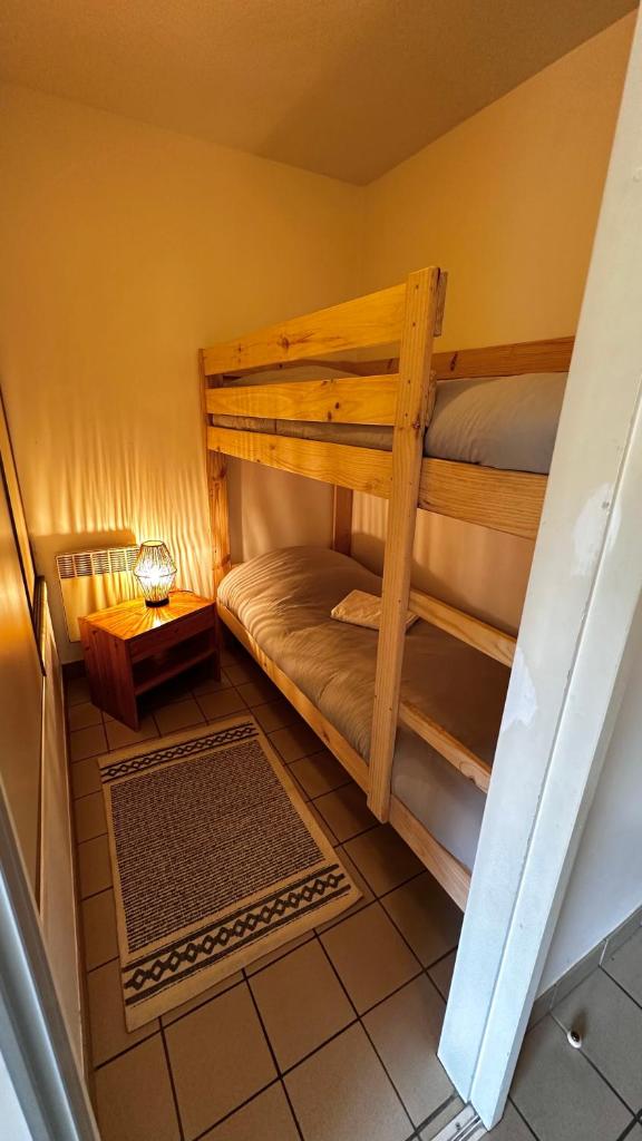 une chambre avec deux lits superposés et une table dans l'établissement Appartement Centre Ville pied de piste Briançon, à Briançon