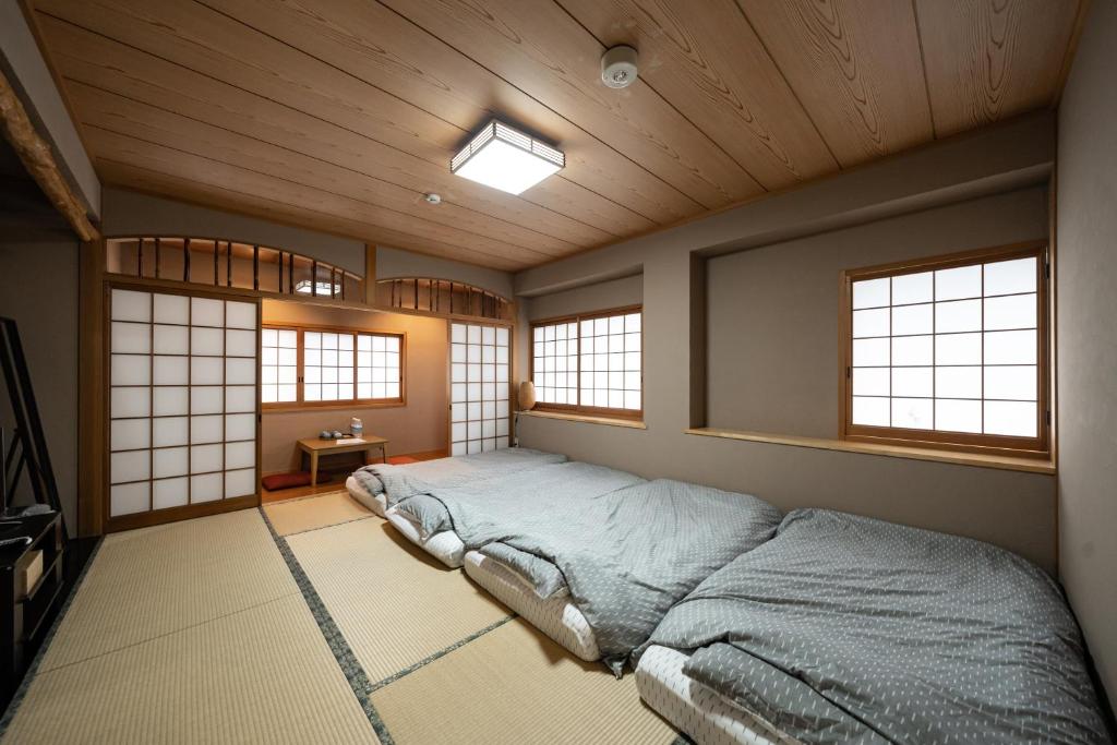 une chambre avec un lit dans une pièce avec des fenêtres dans l'établissement 素泊り旅館 Yururi, à Yufu 34 autres photos
