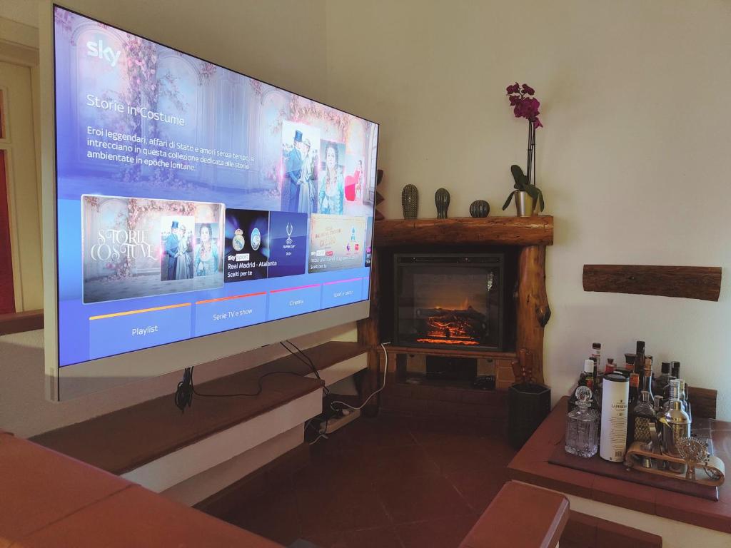 un téléviseur grand écran dans un salon avec une cheminée dans l'établissement Villa Clarenza - Holiday House, à San Pietro Clarenza 17 autres photos
