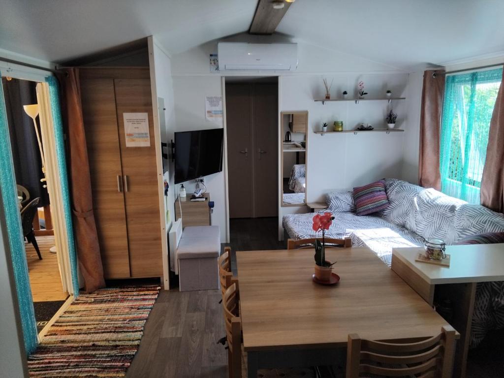 un salon avec une table et un canapé dans l'établissement MOBIL HOME GLAMPING CONFORT D'UN HOTEL SANS LES CONTRAINTES PISCINE PROMOTION SEPTEMBRE 3 CHAMBRES - 2 SdB -climatisé - 300m de la mer - piscine - parking -, à Hyères