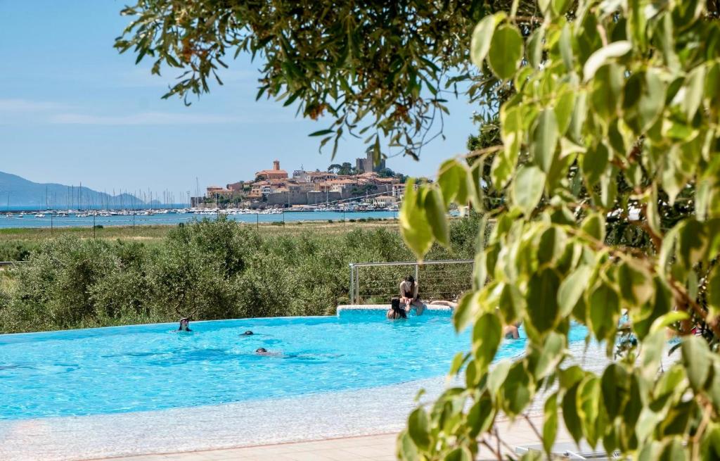 une grande piscine avec des gens dans l'eau dans l'établissement Residence with pool and private beach in Talamone just 500 mt from the sea, à Talamone