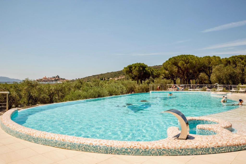 - une piscine avec un dauphin dans l'eau dans l'établissement Residence with pool and private beach in Talamone just 500 mt from the sea, à Talamone