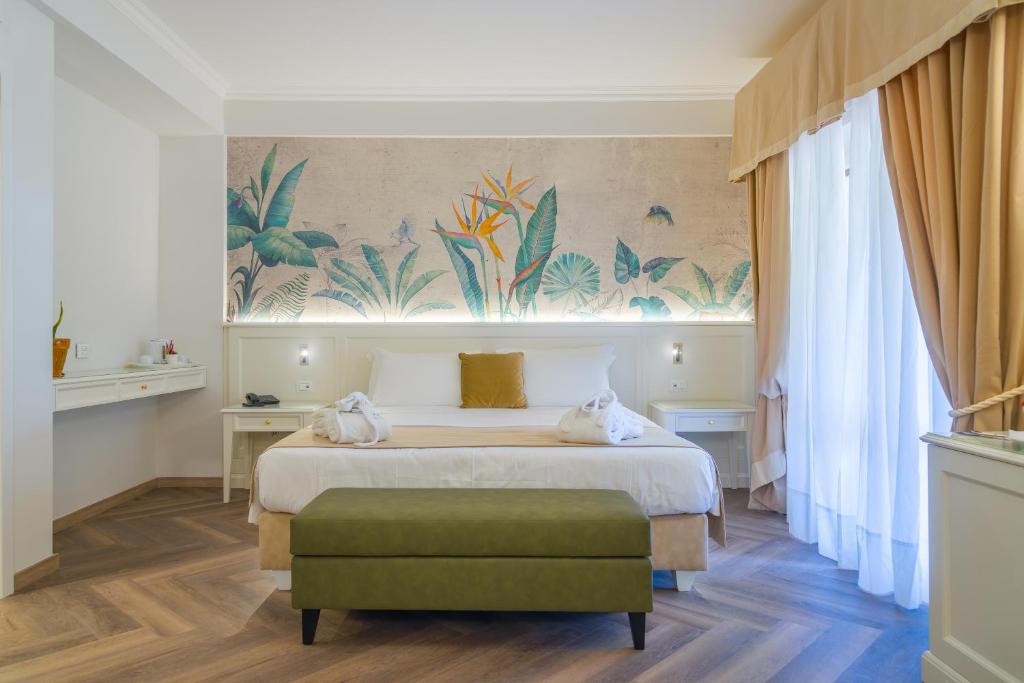 une chambre d'hôtel avec un lit et un pouf vert dans l'établissement Hotel Villa Ottone, à Portoferraio