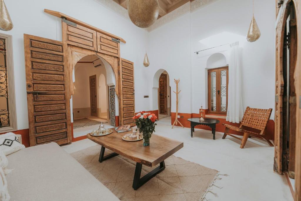 un salon avec un vase de fleurs sur une table dans l'établissement Dar Akal, à Marrakech