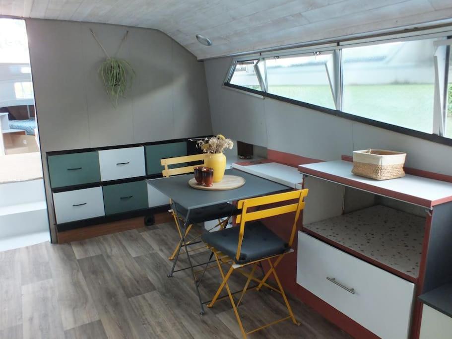 une chambre avec une table et des chaises dans un bateau dans l'établissement Nuits insolites sur un bateau, à Saint-Hilaire-la-Palud