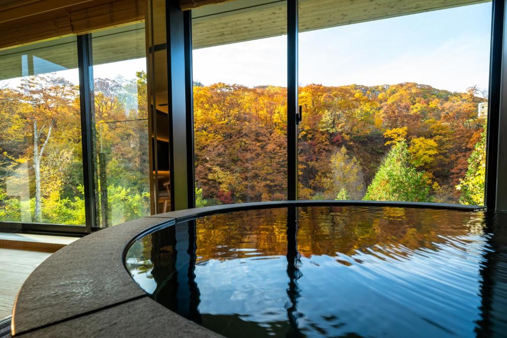 - une table en verre dans une chambre avec vue dans l'établissement Chalet Ivy Jozankei, à Jozankei