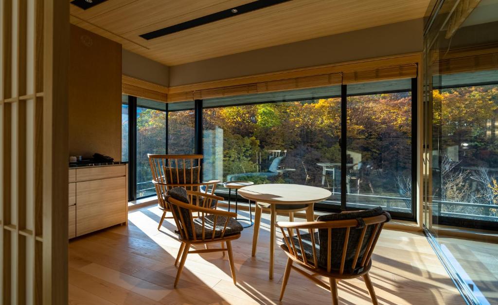 une salle à manger avec une table et des chaises et une grande fenêtre dans l'établissement Chalet Ivy Jozankei, à Jozankei