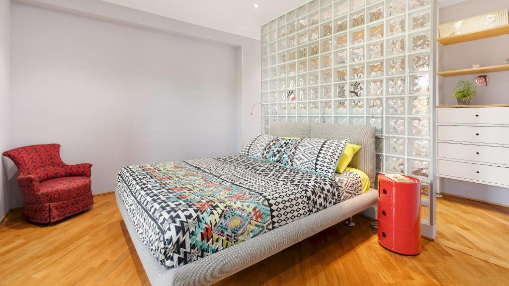 une chambre avec un lit et une chaise rouge dans l'établissement VILLA TIBERIO 6&2, Emma Villas, à Genzano di Roma 40 autres photos