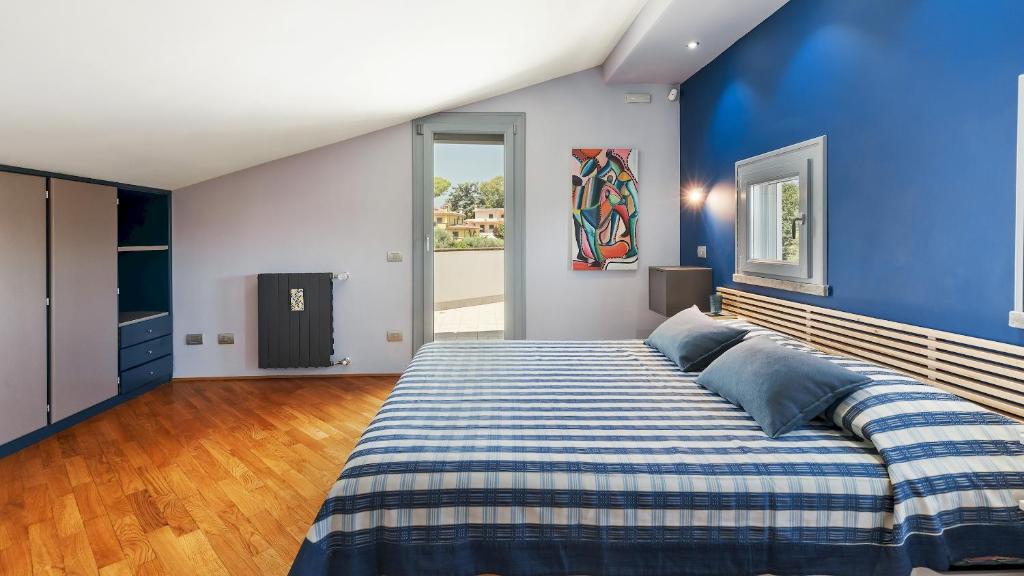 une chambre avec un grand lit aux murs bleus dans l'établissement VILLA TIBERIO 6&2, Emma Villas, à Genzano di Roma