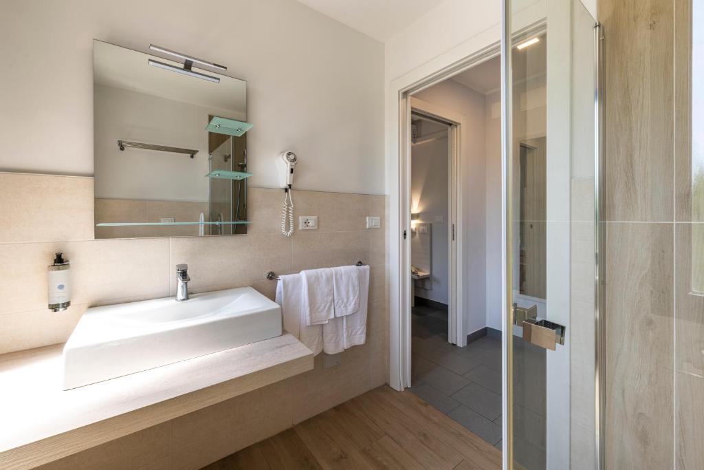 une salle de bain avec un lavabo blanc et un miroir dans l'établissement Hotel La Siesta, à Lido di Jesolo 63 autres photos