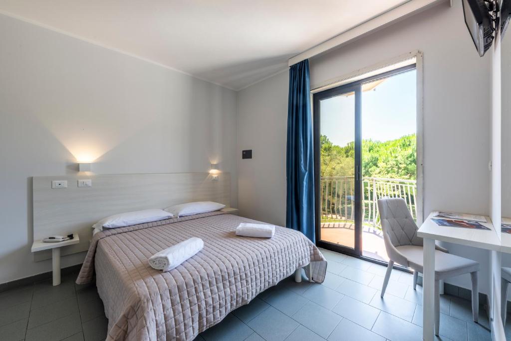 une chambre avec un lit et une grande fenêtre dans l'établissement Hotel La Siesta, à Lido di Jesolo