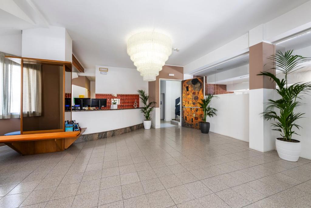 un hall d'entrée avec des plantes en pot dans un immeuble dans l'établissement Hotel La Siesta, à Lido di Jesolo