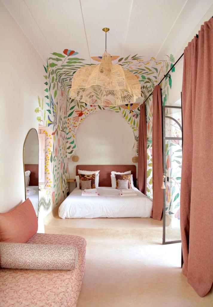 une chambre avec un lit à baldaquin dans l'établissement Riad Pompon, à Marrakech