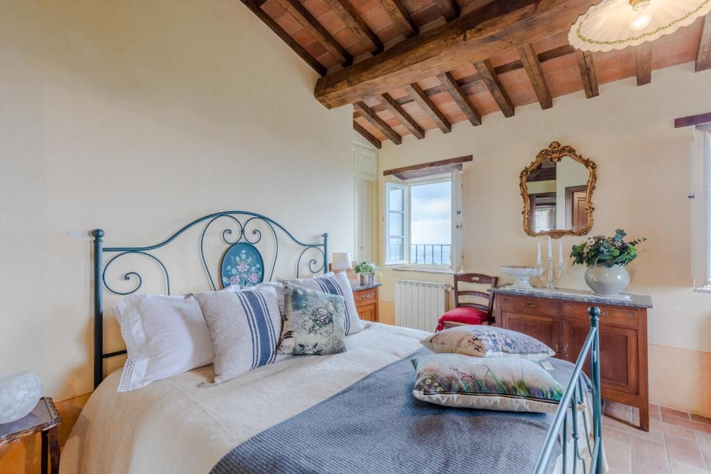 une chambre avec un grand lit et un miroir dans l'établissement Tuscan Fizz, a traditional Stone villa with Pool, à Piaggiori