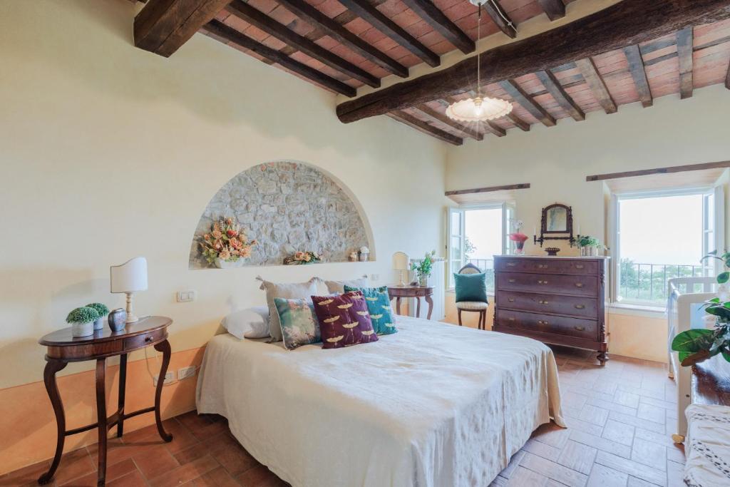 - une chambre avec un lit, une commode et des fenêtres dans l'établissement Tuscan Fizz, a traditional Stone villa with Pool, à Piaggiori