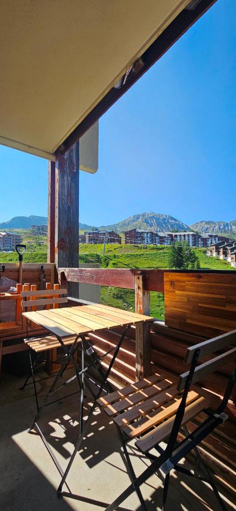 une table en bois et une chaise sur une terrasse couverte dans l'établissement Le balcon du soleil, Pied de pistes 2100m 5 pers Plagne Soleil paradiski, à La Plagne Tarentaise