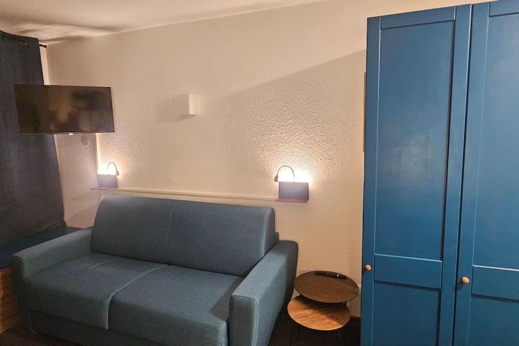 un salon avec un canapé bleu et une armoire bleue dans l'établissement Le balcon du soleil, Pied de pistes 2100m 5 pers Plagne Soleil paradiski, à La Plagne Tarentaise
