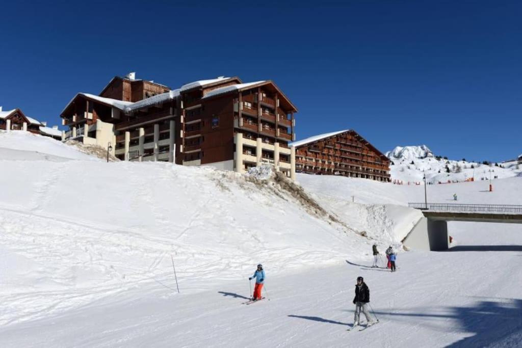 Un groupe de personnes skier dans la neige devant un bâtiment dans l'établissement Le balcon du soleil, Pied de pistes 2100m 5 pers Plagne Soleil paradiski, à La Plagne Tarentaise 23 autres photos