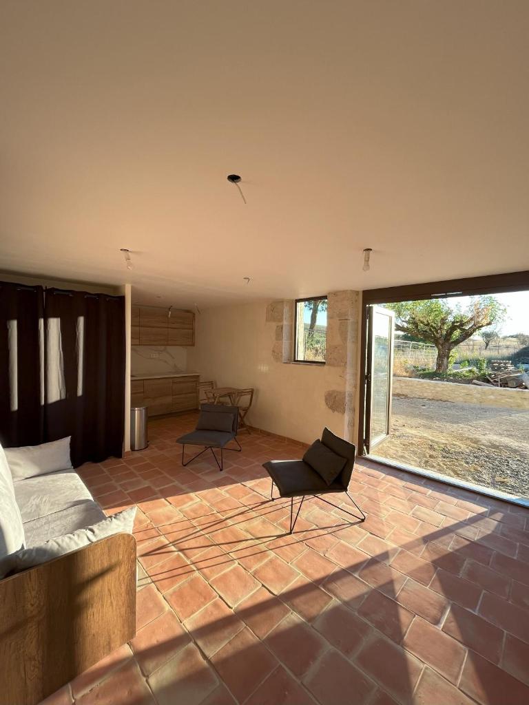 un salon avec une grande fenêtre et un canapé dans l'établissement Gîte Le Studio - Domaine Lassalle Saint-créac, à Saint-Créac
