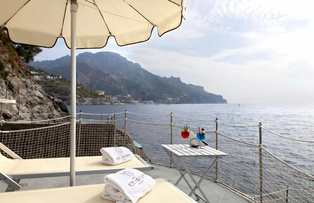 un bateau avec une table et un parasol et l'eau dans l'établissement Ravello Art Hotel Marmorata, à Ravello