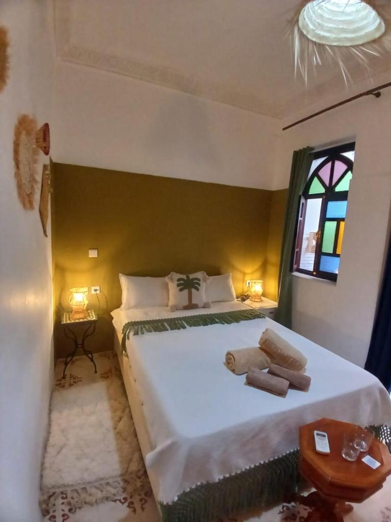 une chambre avec un grand lit blanc avec une fenêtre dans l'établissement Riad Dantella, à Marrakech