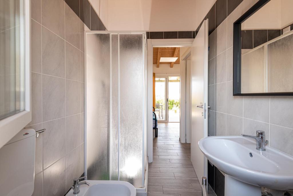 une salle de bain avec un lavabo, des toilettes et un miroir dans l'établissement La Rondine, à Calambrone