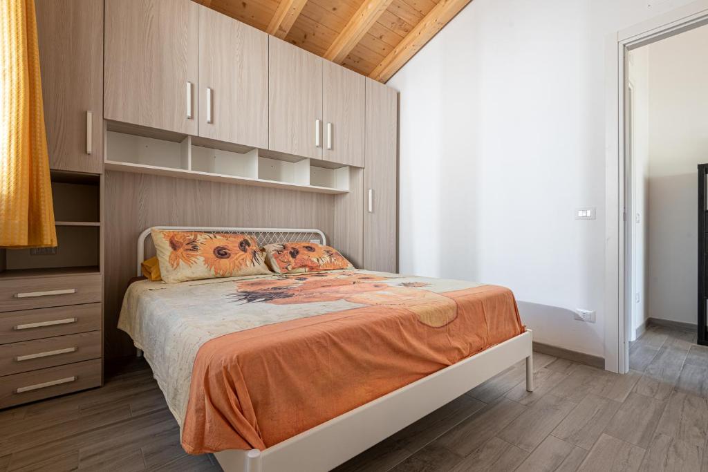 une chambre avec un lit avec une couverture orange dans l'établissement La Rondine, à Calambrone