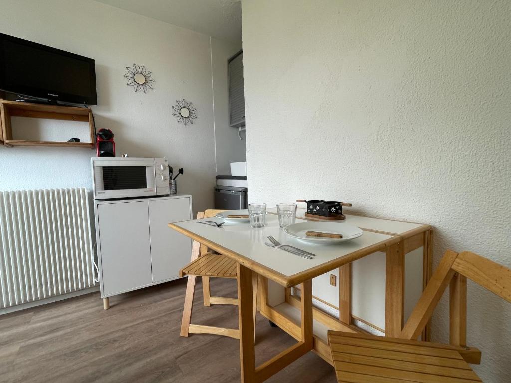 une petite cuisine avec une table et un micro-ondes dans l'établissement Studio accès direct à la Croisette, au coeur des Menuires, aux Menuires