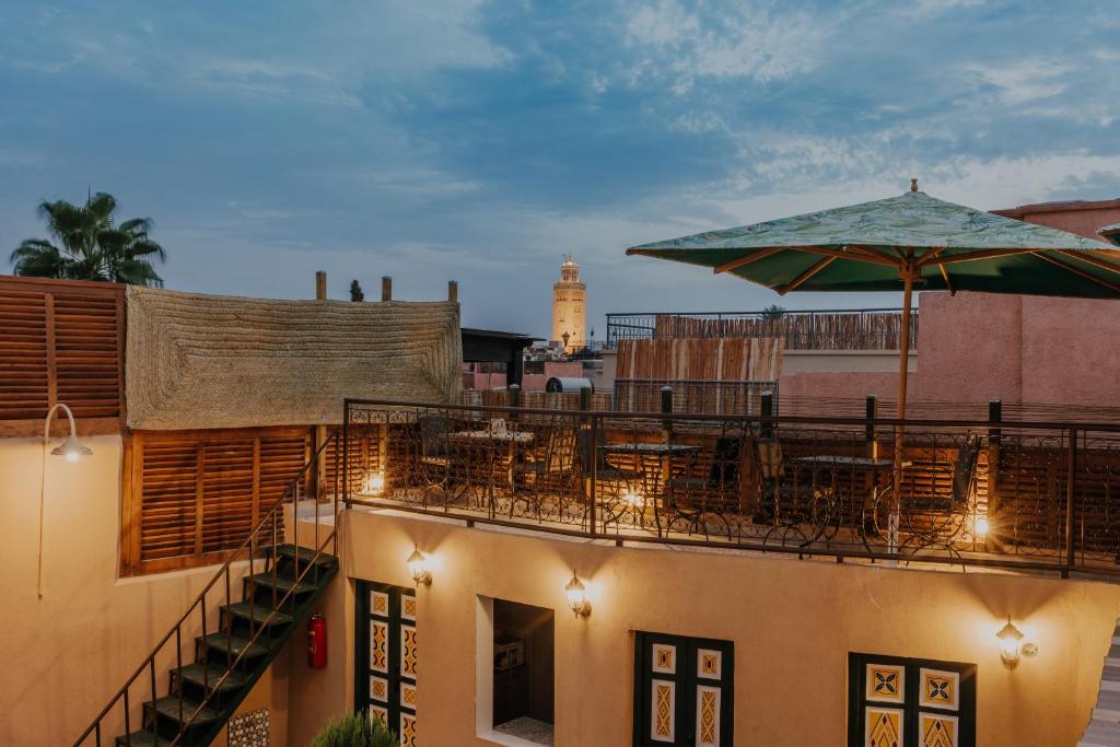 - un balcon avec des tables et des parasols dans un bâtiment dans l'établissement The Little Hara, à Marrakech