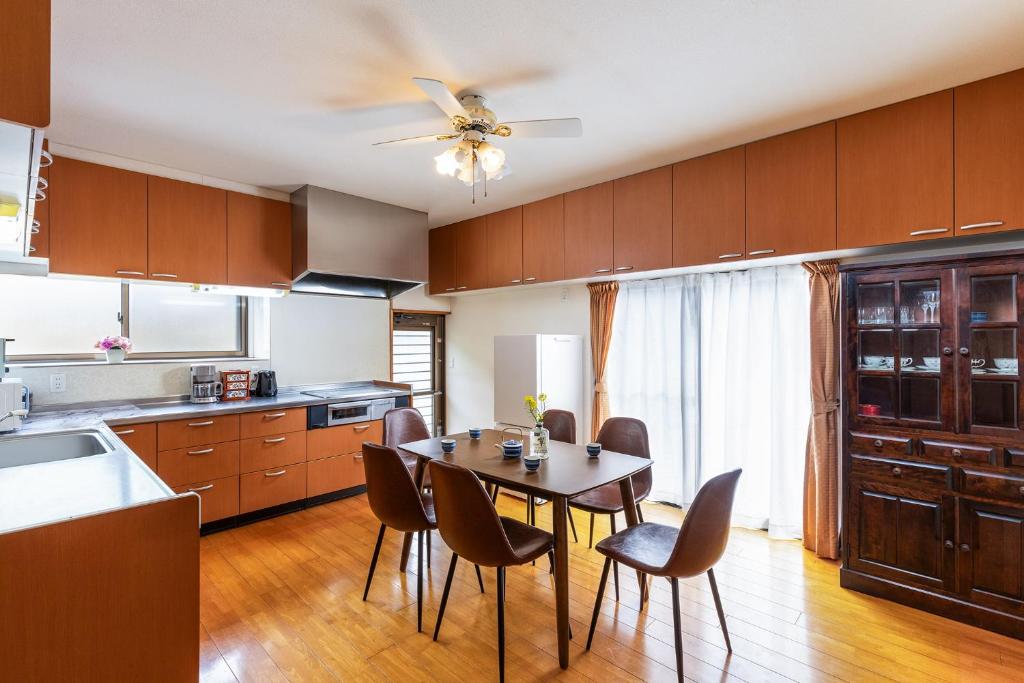 une cuisine avec une table et des chaises ainsi qu'un ventilateur de plafond dans l'établissement Rakushinkan Villa, à Yufu