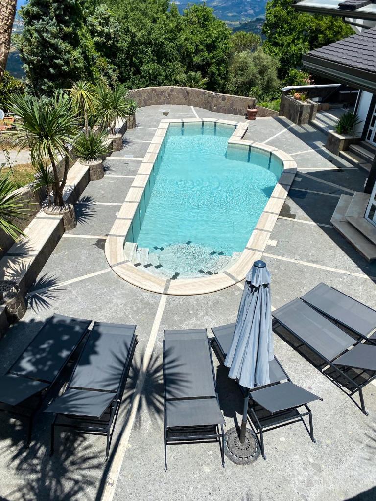 une piscine avec deux chaises et un parasol dans l'établissement Villa Lila, à Laureana Cilento