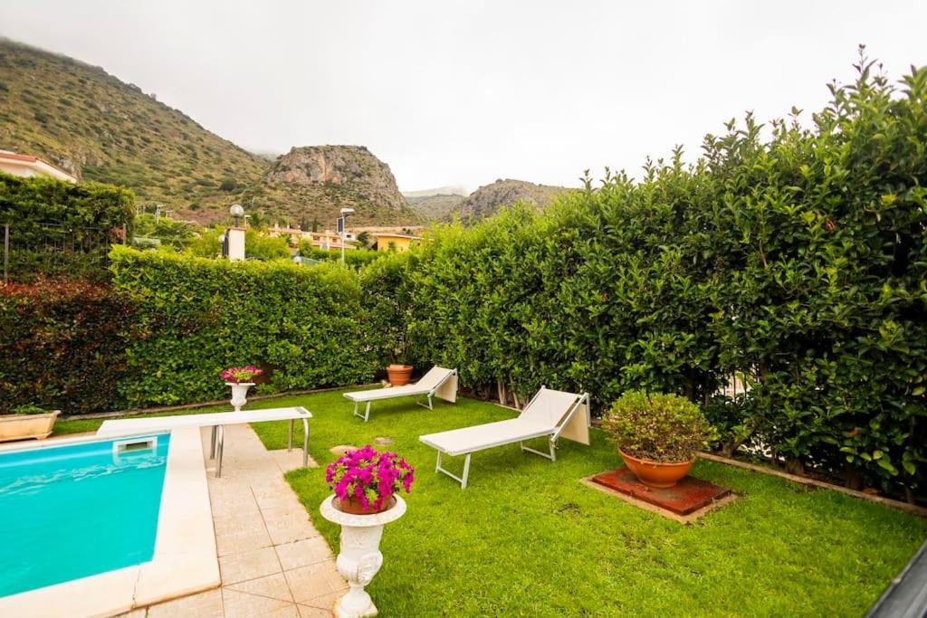 une cour avec une piscine et une pelouse avec des chaises dans l'établissement Villa Carmen, à Mandra Capreria