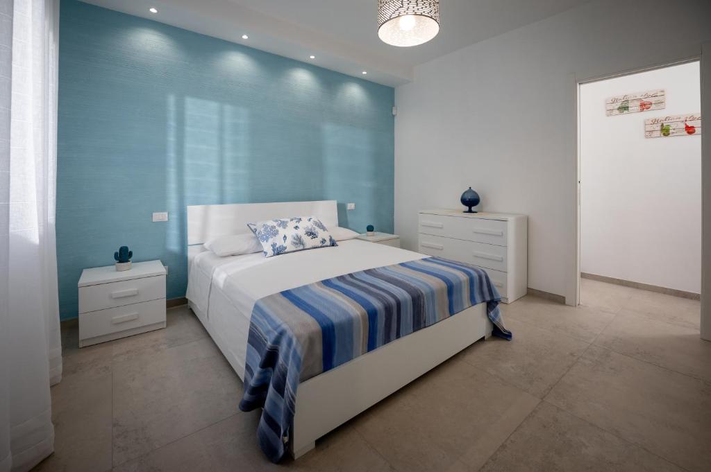 une chambre avec un lit et un mur bleu dans l'établissement Leporano villa MADIA con piscina, Taranto, à Leporano Marina
