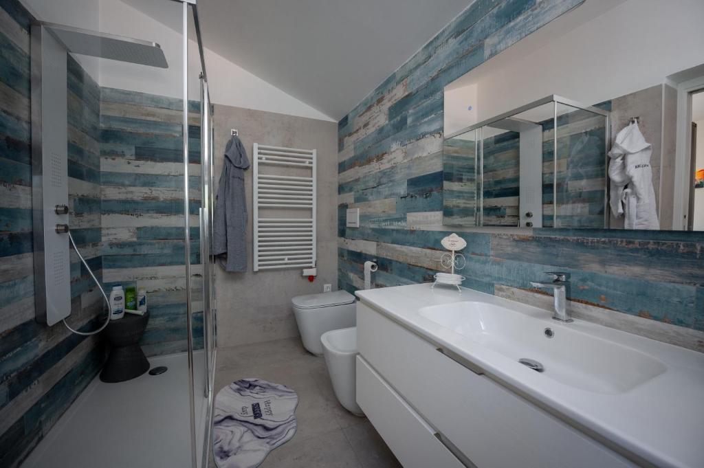 une salle de bain avec un lavabo, des toilettes et un miroir dans l'établissement Leporano villa MADIA con piscina, Taranto, à Leporano Marina 13 autres photos