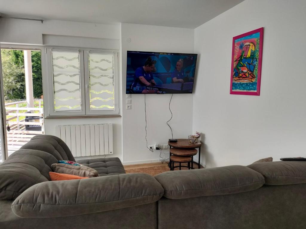 un salon avec un canapé et une télévision à écran plat dans l'établissement bel appartement 3 pièces dans la Résidence Vosges-Alsace Orbey, à Orbey