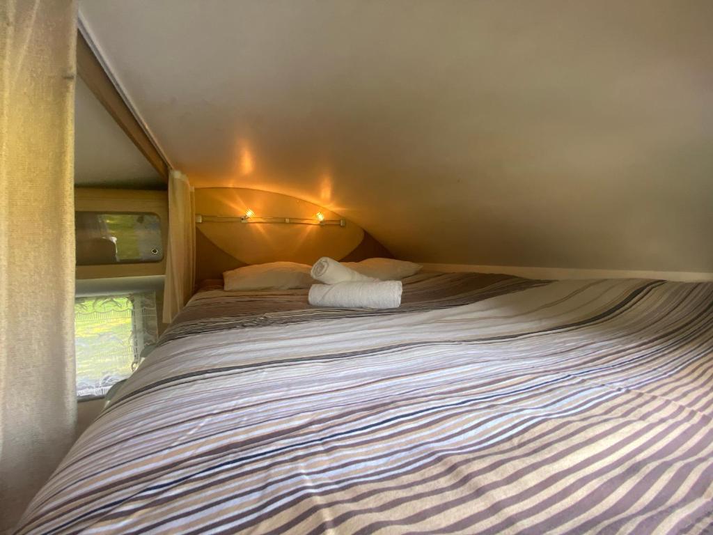 Cette petite chambre comprend un grand lit. dans l'établissement Camping-car au Charme de la Forêt Circuit des 25 Bosses, à Le Vaudoué 37 autres photos