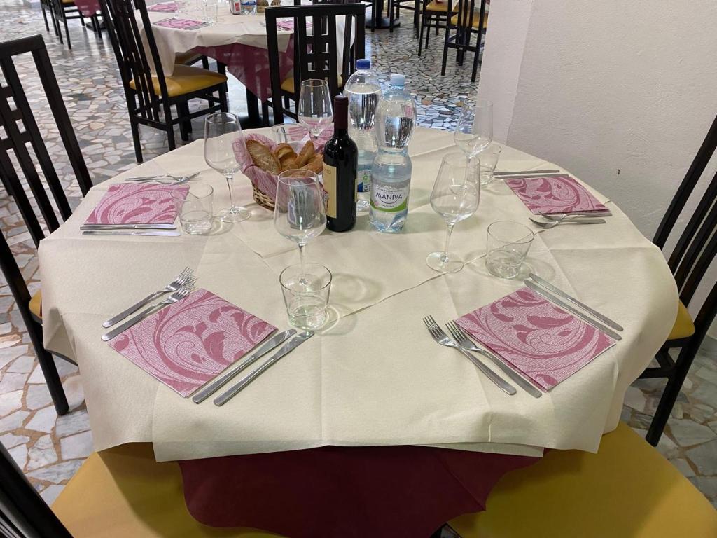 - une table avec un chiffon de table blanc et des verres à vin dans l'établissement Sacro Cuore Hotel, à Marina di Massa