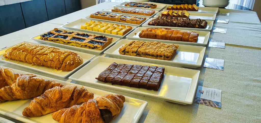 une table surmontée de plateaux de pâtisseries et de desserts dans l'établissement Hotel Manuela, à Cervia