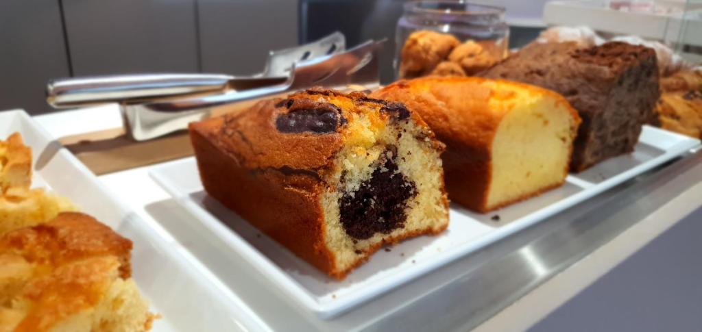 une assiette blanche avec un morceau de gâteau et d'autres desserts dans l'établissement Hotel Manuela, à Cervia 16 autres photos