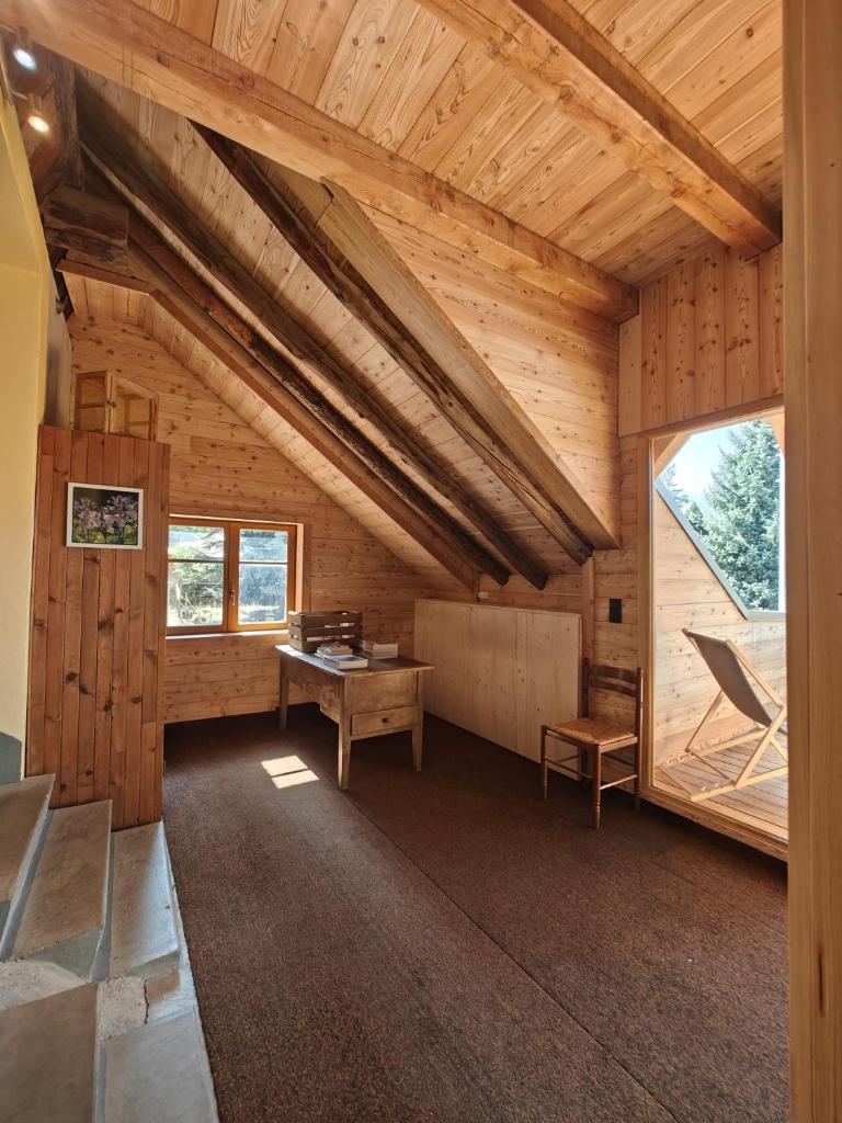 une grande chambre avec un bureau dans une cabane en bois dans l'établissement "La bâtisse des prés", à Puy-Saint-Vincent